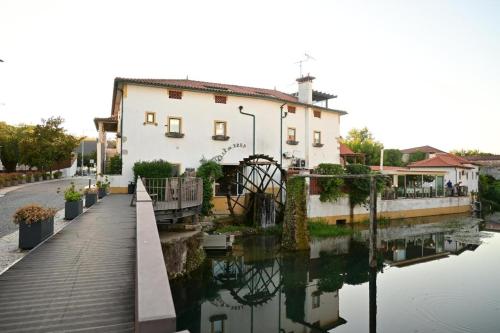 a building next to a river with a bridge at Hotel Casa da Nora in Leiria