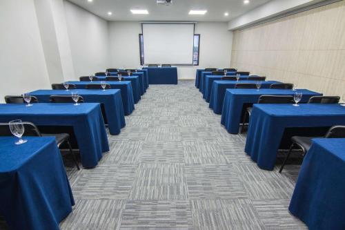 a conference room with blue tables and a whiteboard at Sonesta Hotel Ibagué in Ibagué