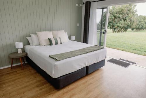 a bedroom with a bed and a large window at Elysian Hills in Carool