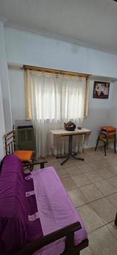 Una sala de estar con una mesa y una manta morada. en Departamento Colón a 2 cuadras de la costa, en Mar del Plata