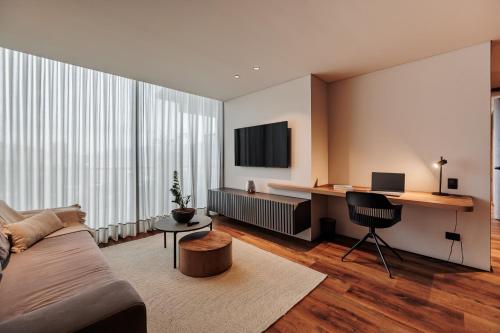 a living room with a couch and a desk at Kiin Living- "Child-free coliving" in Medellín