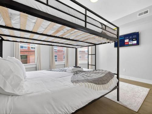 une chambre avec un lit superposé avec des draps blancs dans l'établissement Luxury 3BR apt in Boston that Sleeps 10, à Boston