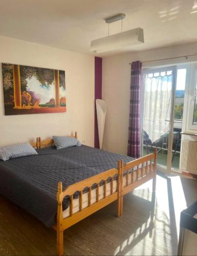 a bedroom with a bed and a large window at Ferienwohnungen Ferienhaus Nähe Winterberg Upland in Bromskirchen