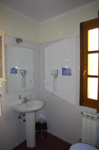 a white bathroom with a sink and a mirror at Pensión Arbidel in Ribadesella