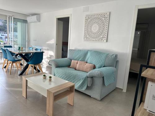 a living room with a blue couch and a table at Delmar Apartment in Alicante