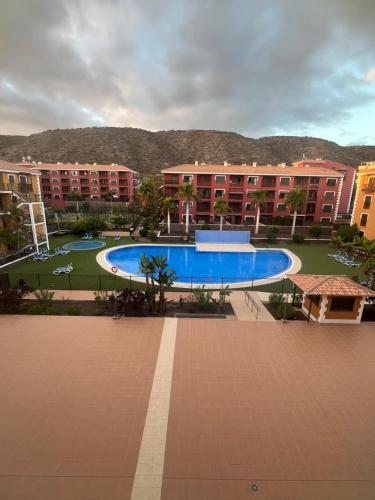 une piscine devant un grand bâtiment dans l'établissement Premium Apartment in Palm Mar, à Palm-mar