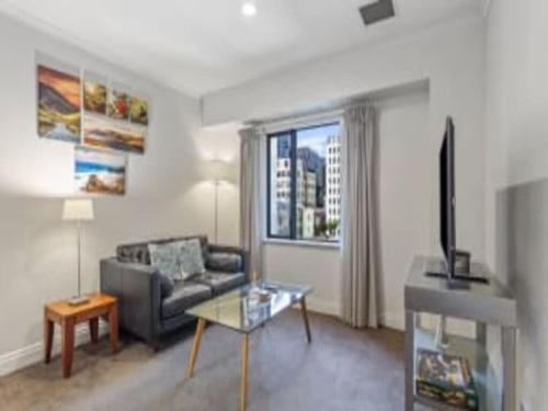 Una sala de estar con un sofá y una ventana. en Superking Bed in Stylish Apartment I Zodiak Stays, en Auckland