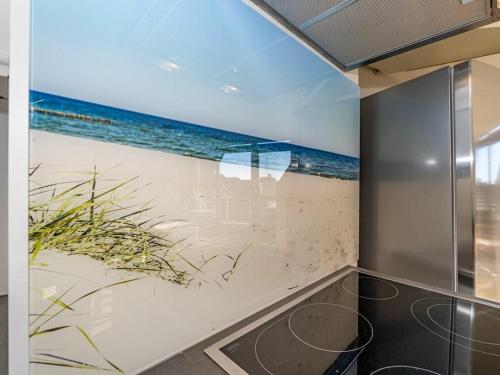 een kamer met een schilderij van een strand en de oceaan bij One-bedroom apartment in Wenningstedt