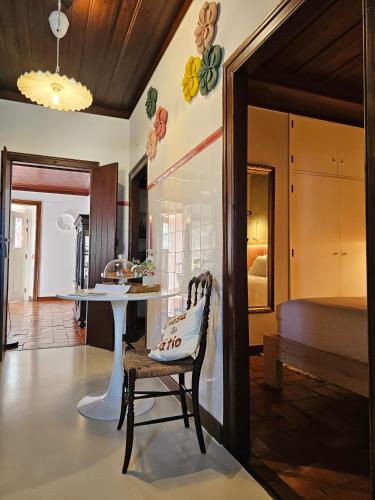 a living room with a table and a chair at Casa do Pátio, casaspensadas in Juncal
