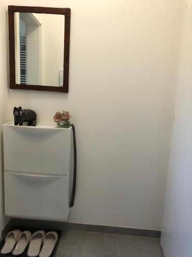 a bathroom with a mirror and a white refrigerator at Apartment Prague Airport- 5 minute drive from AirPort in Tuchoměřice