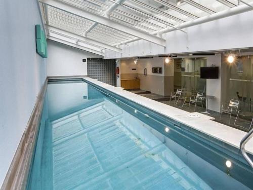 a large swimming pool in a building with a kitchen at Beautiful and Spacious 1BR in CBD by Zodiak Stays in Auckland