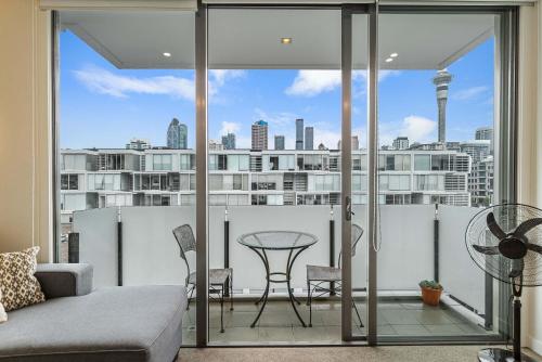a living room with a view of a city at Beautiful 2BR - Pool, Gym & Parking Zodiak Stays in Auckland