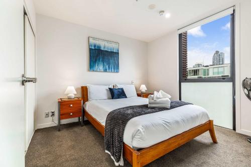 a bedroom with a bed and a window at Beautiful 2BR - Pool, Gym & Parking Zodiak Stays in Auckland