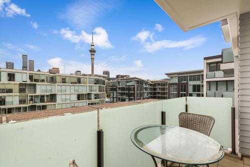 a balcony with a glass table and a view of the city at Beautiful 2BR - Pool, Gym & Parking Zodiak Stays in Auckland