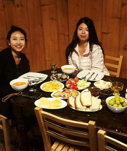 two women sitting at a table full of food at Elos Guesthouse in Iprari
