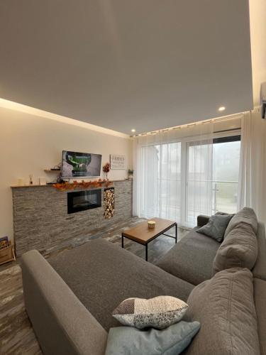 Una sala de estar con un sofá y una chimenea. en Zlatni Breg Divcibare, en Divčibare