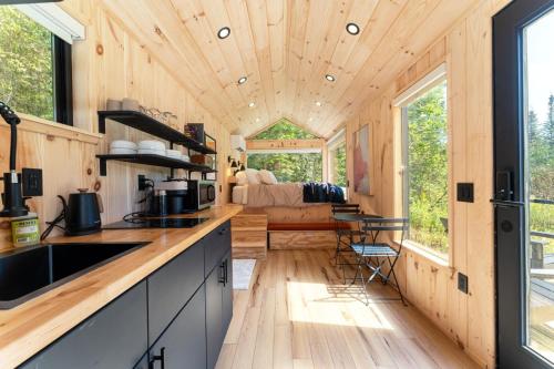 a kitchen with a wooden ceiling and a living room at Vesta Nook With Shower Queen Bed & pullout sofa in Sullivan