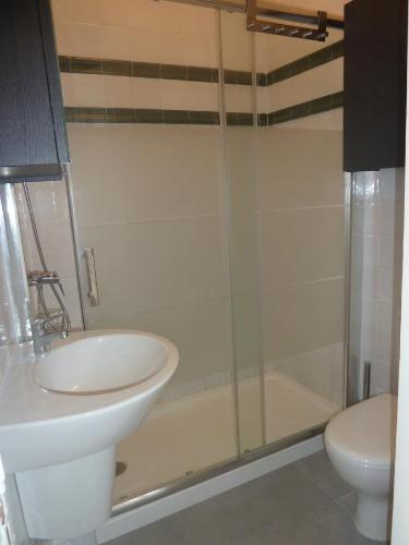 a bathroom with a sink and a shower and a toilet at Casa do Beco in Lisbon