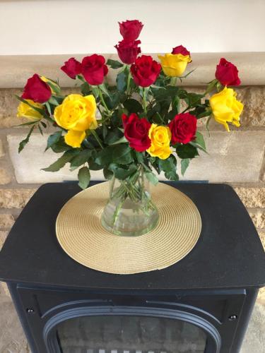 a vase of flowers sitting on a table at Cornerways B&B in Chipping Campden