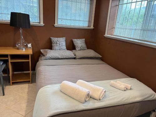 two beds in a room with two windows at Relaxing Private Room, Quiet and Convenient in Vancouver