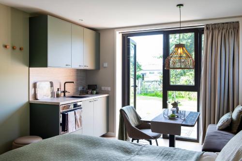 a kitchen with a bed and a table in a room at Het Moleneind - Studio en Vakantiehuis in Kapel-Avezaath