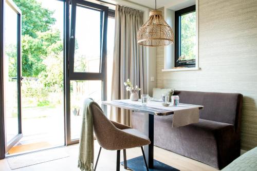 a dining room with a table and a chair at Het Moleneind - Studio en Vakantiehuis in Kapel-Avezaath