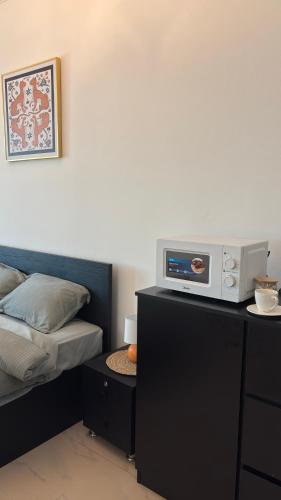 a bedroom with a bed and a microwave on a counter at Qantab village room in Muscat