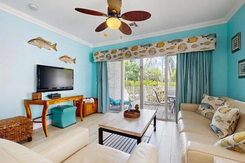 Una sala de estar con un sofá y un televisor de pantalla plana. en Harbor Villa, en Duck Key