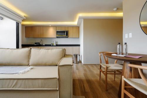 a living room and kitchen with a couch and a table at Colima 340 by Wynwood House in Mexico City