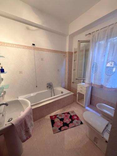 a bathroom with a tub and a toilet and a sink at Casa da Rosaria in Taormina