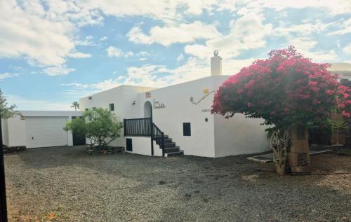 un bâtiment blanc avec un escalier et un arbre dans l'établissement Detached Villa with Stunning Mountain and Sea Views, 14m Pool & sunken Hot Tub, à Puerto del Carmen