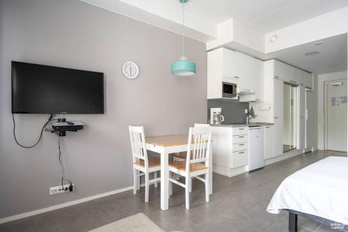 a room with a table and two chairs and a tv at Sivulantie 4 109 by Holiday in Lapland in Äkäslompolo