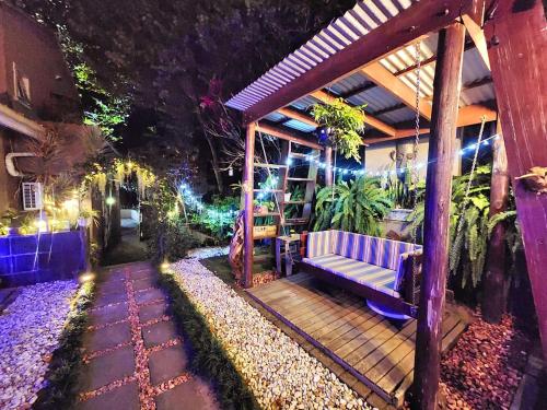 a porch with a purple bench on a patio at night at Maple Tree Manor in Durban