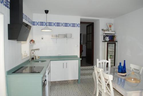 eine Küche mit Spüle und Tisch mit Stühlen in der Unterkunft La Casa de Antonina in Castilblanco de los Arroyos
