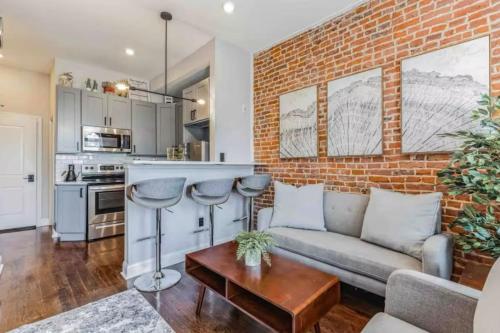 a living room with a couch and a brick wall at Studio w Terrace - Street Parking -10 min to DT in Philadelphia