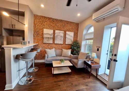 a living room with a couch and a brick wall at Studio w Terrace - Street Parking -10 min to DT in Philadelphia