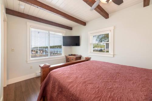 a bedroom with a bed and a flat screen tv at Sunny Shores - Lake days, Pool dips & Concerts in Dockham Shore
