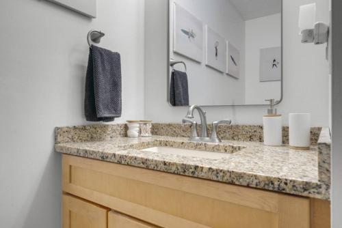 a bathroom with a sink and a mirror at Lakeview Retreat Modern 2BR Condo on Newfound Lake in Bristol