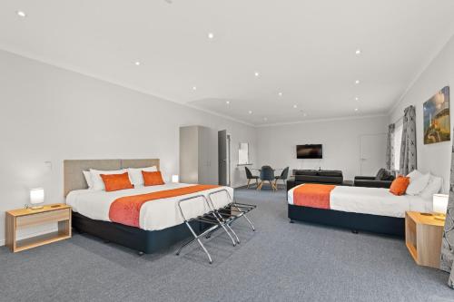 a bedroom with two beds and a living room at ASURE Oak Estate Motor Lodge in Greytown