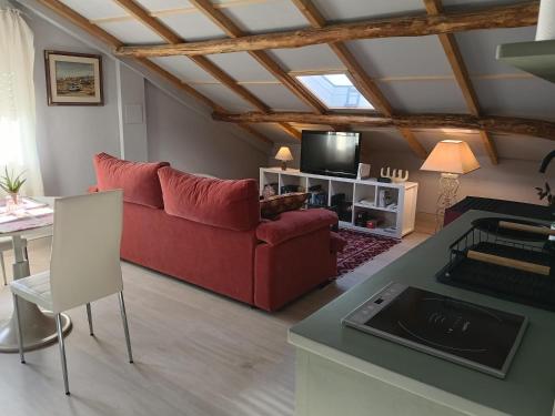 a living room with a red couch and a table at Apartamento Riazón3 in Ourense