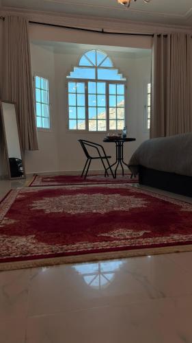 a bedroom with a bed and a table and a window at Qantab village room in Muscat