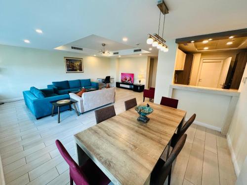 a living room with a table and a blue couch at Mountain View Luxury Centaurus Mall Apartment Islamabad in Islamabad