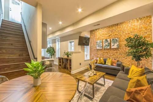 a living room with a couch and a brick wall at Lovely 2BR w Patio - 10 mins to DT - Sleeps 10 in Philadelphia