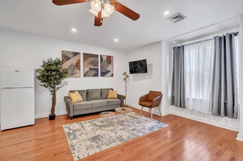 a living room with a couch and a ceiling fan at Huge and Sunny 1BR in Center City in Philadelphia