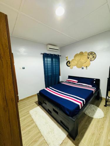 una camera da letto con un letto con un piumone blu di Ilé Ifè a Cotonou