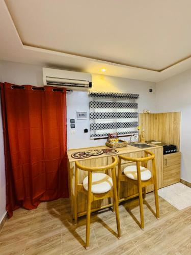 una cucina con un tavolo di legno e due sedie di Ilé Ifè a Cotonou