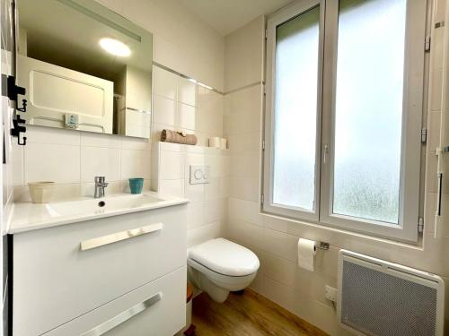 a bathroom with a toilet and a sink and a window at Ty Heol, maison authentique, lumineuse avec jardin in Saint-Caradec-Trégomel