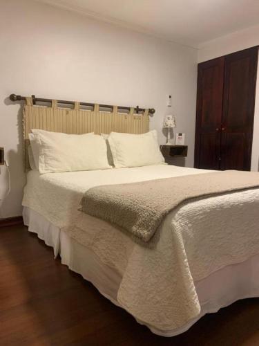 a bedroom with a large bed with white pillows at Tierra y Vino al lado del casino y museo tu mejor opción in Santa Cruz