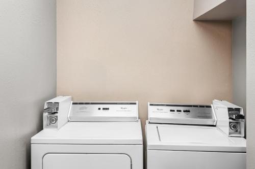 two washing machines sitting next to each other in a room at Holiday Inn Express Hotel & Suites Charleston-Southridge by IHG in Charleston