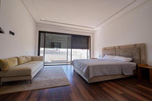 a bedroom with a bed and a couch and a window at Jack Beach Bay in Tamaris